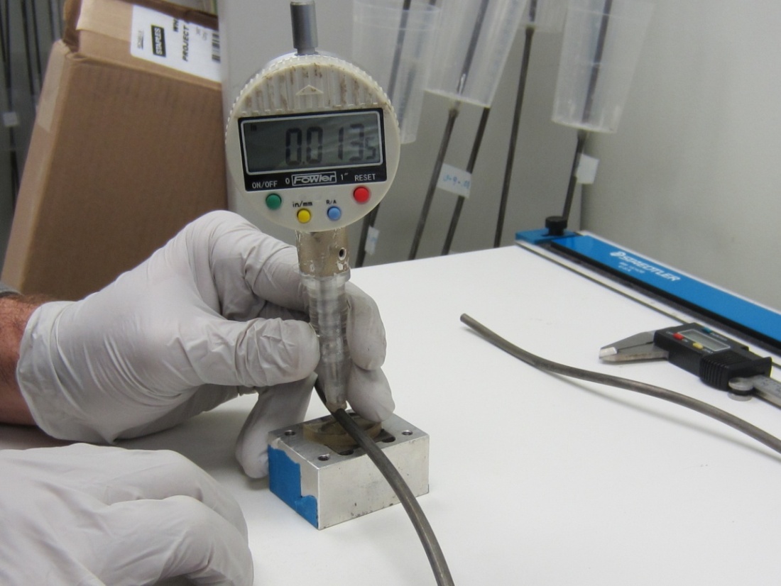 Figure 77. Photo. Pit depth measurement using a digital pit gauge. This photo shows a pit depth measurement in progress using a digital pit gauge. The pit gauge shows a depth reading of 13.5 mil.