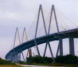 This photo shows the Fred Hartman Bridge in Houston, TX. Taken from land, it shows the diamond-shaped towers that support the stay cable system and the main and side spans of the bridge.