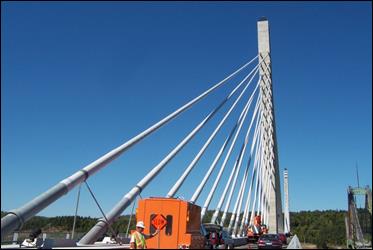 This photo, taken from roadway at the end of the side span, shows the cables extending from the bridge deck up to the pylon. The cables emerge in single file from the deck but rearrange themselves slightly as they approach the pylon, as cables are situated side-by-side in pairs at the pylon's cradle points. This photo, taken from roadway at the end of the side span, shows the cables extending from the bridge deck up to the pylon. The cables emerge in single file from the deck but rearrange themselves slightly as they approach the pylon, as cables are situated side-by-side in pairs at the pylon's cradle points.