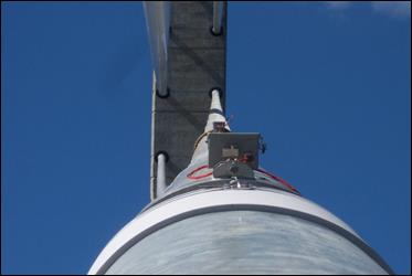This photo, taken from the perspective of the surface of a cable, faces upwards towards the pylon. In the foreground an accelerometer sits attached to the top of a cable, and further up in the distance, the second accelerometer is also visible.