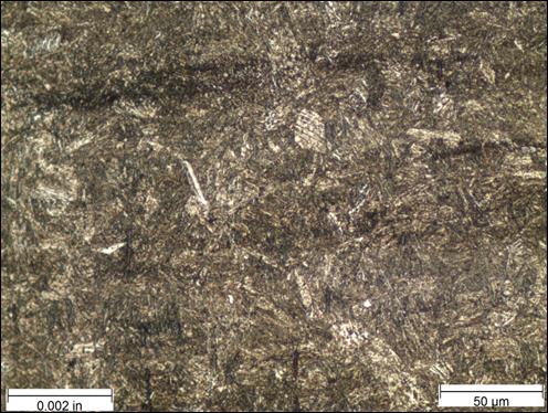 Figure 28. Photo. Micrograph near thread root etched with Marshall’s reagent at 500x magnification. This photo shows a micrograph that was taken near the thread roots of the threaded rod at a magnification of 500x and viewed under bright field illumination. The sample was etched with Marshall’s reagent. A scale bar with a length of 0.002 inches is shown in the lower left corner of the photo, and a scale bar with a length of 50 micrometers is shown in the lower right corner. The microstructure is mostly brown and appears as a needle-like martensite structure throughout most of the photo. Figure 28. Photo. Micrograph near thread root etched with Marshall’s reagent at 500x magnification. This photo shows a micrograph that was taken near the thread roots of the threaded rod at a magnification of 500x and viewed under bright field illumination. The sample was etched with Marshall’s reagent. A scale bar with a length of 0.002 inches is shown in the lower left corner of the photo, and a scale bar with a length of 50 micrometers is shown in the lower right corner. The microstructure is mostly brown and appears as a needle-like martensite structure throughout most of the photo.