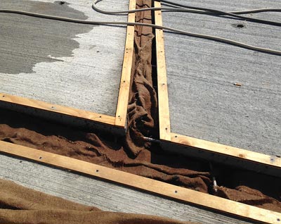 This photo shows the pre-wetting operation of a prefabricated bridge element connection using burlap sheets that are kept saturated with water at all times.