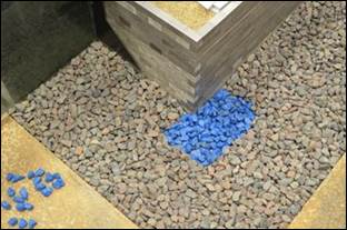 Figure 7. Photos. Riprap installation. This photo shows a close-up of the test at the upstream corner of the abutment with the surrounding riprap apron. The rocks are color-coded so that their motion and final location can be determined. Figure 7-A. Photo. Bottom layer. This photo shows a close-up of the test at the upstream corner of the abutment with the surrounding riprap apron. A rectangular section of riprap installed as part of the bottom layer or riprap is shown in a color different than the surrounding riprap. The rocks are color-coded so that their motion and final location can be determined.