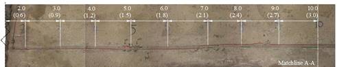 This figure shows the top of the two girders and the connection from the 2- to 10-ft (0.61 to 3.05-m) mark. Various marker lines are present on the connection grout and the interface between the beams and the connection. Red marker is visible throughout the entire connection, which indicates the extent of the mechanical cracking.