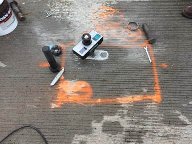 This figure shows a photo from in-situ bond testing on the Laporte Road bridge. The photo shows the bond test machine running a test.