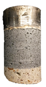 Figure 31-B. Photo. Back of G2-9 specimen after testing. This photo shows the back of the specimen where the steel test disc, UHPC overlay, and the substrate concrete can be observed. Mode 4 failure is evident by a thin crack between the test disc and the UHPC overlay material.
