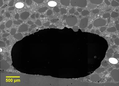 Figure 34. This figure shows an electron microscope image that depicts a void between UHPC overlay and the existing deck concrete. The image has a scale bar in the bottom lefthand corner measuring 500 μm.