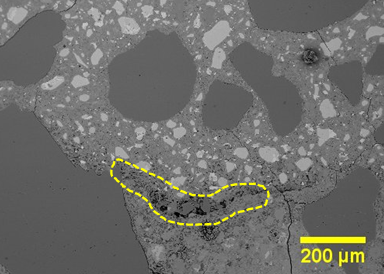 Figure 35. This figure shows an electron microscope image that depicts poor consolidation or accumulation of debris between UHPC overlay and the existing deck concrete. The image has a scale bar in the bottom righthand corner measuring 200 μm.