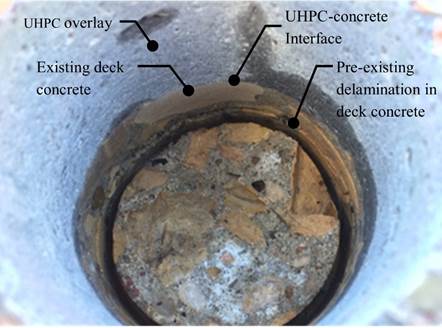 Figure 42. This figure is a photo of the B7-11 core location after testing and removal of the test specimen. The UHPC overlay material appears to be bonded well to the existing deck concrete. This is evident because cracks do not exist at the UHPC-concrete interface. A pre-existing delamination in deck concrete is apparent.