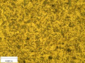 A scale bar is provided in the picture showing a dimension of 0.001 inch, and therefore the field of view is approximately 0.005 inch wide and 0.0038 inch tall. The image comprises two types of microstructures: light and dark. Both microstructures appear to be randomly distributed through the image and have grain sizes on the order of 0.0002 inch.