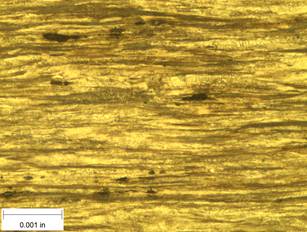 A scale bar is provided in the picture showing a dimension of 0.001 inch, and therefore the field of view is approximately 0.005 inch wide and 0.0038 inch tall. The image comprises two types of microstructures: light and dark. Both microstructures are elongated across the width of the image and alternately layered through the height of the image.