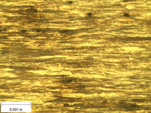 A scale bar is provided in the picture showing a dimension of 0.001 inch, and therefore the field of view is approximately 0.005 inch wide and 0.0038 inch tall. The image comprises two types of microstructures: light and dark. Both microstructures are elongated across the width of the image and alternately layered through the height of the image.