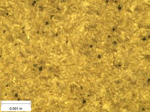 A scale bar is provided in the picture showing a dimension of 0.001 inch, and therefore the field of view is approximately 0.005 inch wide and 0.0038 inch tall. The image comprises two types of microstructures: light and dark. Both microstructures appear to be randomly distributed through the image and have grain sizes on the order of 0.0002 inch. The image also contains a random distribution of round inclusions, also around 0.0002 inch.