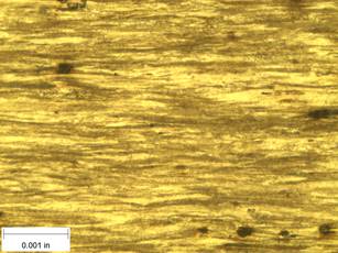 A scale bar is provided in the picture showing a dimension of 0.001 inch, and therefore the field of view is approximately 0.005 inch wide and 0.0038 inch tall. The image comprises two types of microstructures: light and dark. Both microstructures are elongated across the width of the image and alternately layered through the height of the image.