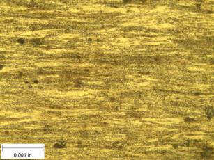 A scale bar is provided in the picture showing a dimension of 0.001 inch, and therefore the field of view is approximately 0.005 inch wide and 0.0038 inch tall. The image comprises two types of microstructures: light and dark. Both microstructures are elongated across the width of the image and alternately layered through the height of the image. The boundaries between the individual microstructures are blurred and not well defined.