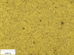 A scale bar is provided in the picture showing a dimension of 0.001 inch, and therefore the field of view is approximately 0.005 inch wide and 0.0038 inch tall. The image comprises two types of microstructures: light and dark. Both microstructures appear to be randomly distributed through the image, though their sizes are too small to distinguish at this level of magnification. The image also contains a few round inclusions around 0.0002 inch in diameter, though their boundaries have started to blend into the microstructure.