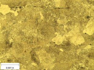 A scale bar is provided in the picture showing a dimension of 0.001 inch, and therefore the field of view is approximately 0.005 inch wide and 0.0038 inch tall. The image comprises two types of microstructures: light and dark. The microstructures are randomly oriented coarse grains with a size of approximately 0.001 inch.