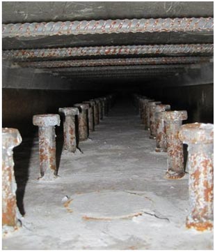 This photo shows the haunch void space immediately before casting ultra-high performance concrete (UHPC). The connection for the steel girder is shown with the two rows of studs on the bottom and the transverse deck reinforcement on the top.