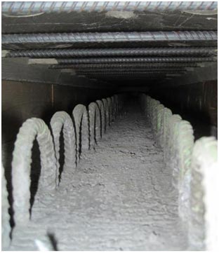 This photo shows the haunch void space immediately before casting ultra-high performance concrete (UHPC). The connection for the concrete girder is shown with two rows of girder shear reinforcement at the bottom and the transverse deck reinforcement at the top.