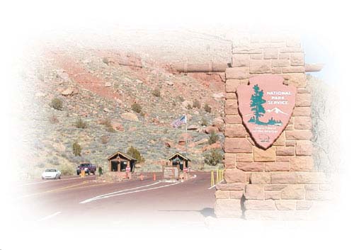 Photograph of the entranced to Zion National Park showing to gatehouses with single entrance lanes passing by each and a third far lane that appears to be an exit lane.