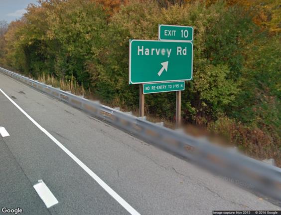 This photo shows an exit sign for exit 10 that reads, “Harvey Rd” with an arrow pointing diagonally up to the right. A smaller sign underneath reads, “NO RE-ENTRY to I-95 N.” 