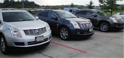 Three 2013 Cadillac SRX from the CAV fleet in a parking lot.