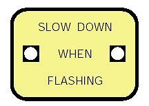 Figure 3-15. Warning sign alerting drivers to unsafe speed. "Slow down when flashing" sign that contains two flashing lights on the sides of the sign.