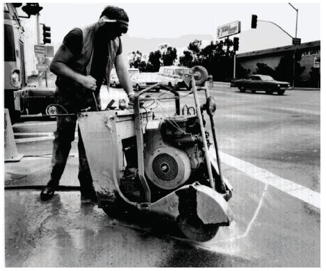 Figure 5-2. Loop sawcut process. Photograph of sawcut being made in pavement by a technician.