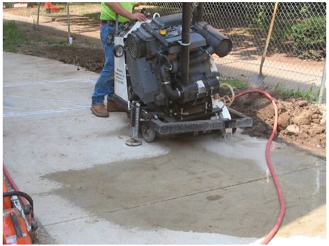 Figure 5-42. Round loop saw at beginning of installation process. Technician anchors circular saw cut machine to center of where sawcut will be made