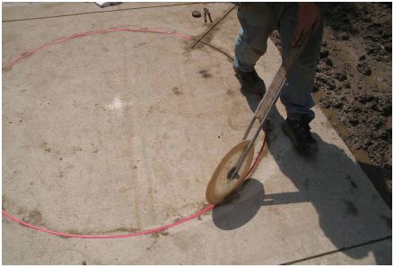 Figure 5-48. Firmly seating backer rod material over loop wire. The technician presses down on the backer rod with the circular wheel which is rolled around the sawcut on top of the loop wire. The pressure forces the backer rod to the top of the loop wire and firmly anchors it in place. If sealant was placed on the bottom of the sawcut, the backer rod forces the loop wire into the sealant.