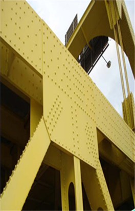 This is a close-up photo of a yellow gusset plate on a bridge.