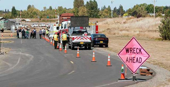 A highway scene with cars and emergency vehicles and a sign that reads 'Wreck Ahead' A highway scene with cars and emergency vehicles and a sign that reads 'Wreck Ahead'