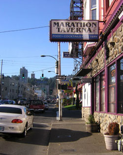 This photo shows that the traffic light and the one-way sign on the post are obscured by the Marathon Taverna and -park in rear- signs. 