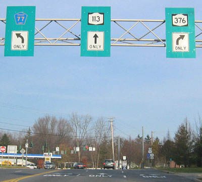 The picture shows an overhead sign where the leftmost lane is a turn lane labeled Frontage Road, the next two left lanes are illinois West 56, I-88 West, and I-355 (a toll interstate). The three through lanes are Highland Avenue, and the right lane is illinois 56 East. 