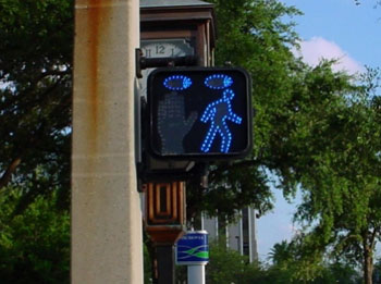 Figure 69. Examples of countdown and animated eyes pedestrian signal displays. Photos. The photo to the left shows a countdown display with a Flashing don't Walk symbol next to a digital number (eight). The digital number counts down second by second and reflects the amount of time remaining during the "flashing don't walk" interval. The photo to the right shows an "animated eyes" display in a fluorescent blue color. The "eyes" are shown directly above the walk symbol and indicate that pedestrians should look out for conflicting movements.