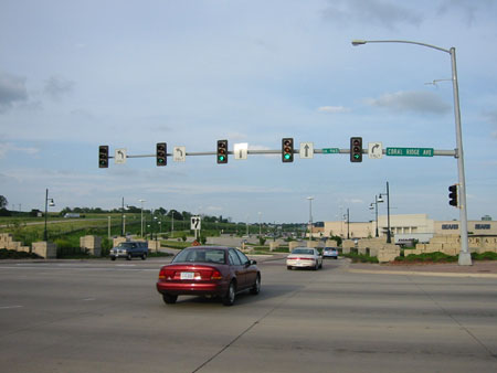 Figure 114. Lane-aligned signal heads. Photo. The picture shows one signal head and lane use signs for each lane of traffic (two left turns, two straight through traffic lanes, and one right turn) placed on a mast arm.