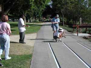 Figure 24: Photo. Temporary pavement markings were tested. Three event staff persons are measuring the distances between the longitudinal lines at the sweep width station.