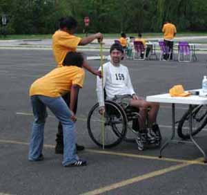 Figure 25: Photo. Registration desk. One participant is talking to two event staff persons at the registration desk. Other participants are standing nearby.