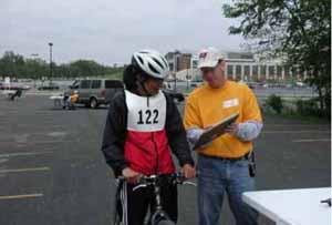 Figure 30: Photo. The participants were briefed at the turning radius station. An event staff person is briefing a participant on a bicycle.