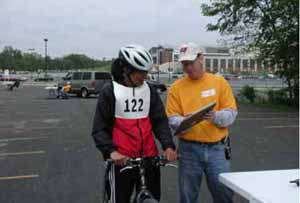 Figure 30: Photo. The participants were briefed at the turning radius station. An event staff person is briefing a participant on a bicycle.