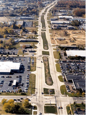 Figure 1. Photo. Example of M U T I T on Michigan corridors. An aerial photograph of median U-turn intersection treatment along a Michigan corridor is shown. The photo illustrates repeated applications along one stretch of a major roadway with many intersections.