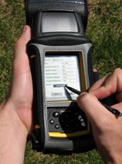 This is a close-up picture of a handheld personal digital assistant. The person holding the device is touching the screen with a stylus.