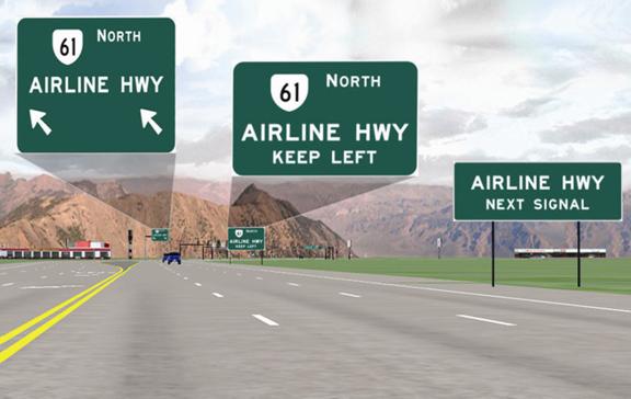 This is a scene from the driving simulation for the overhead treatment. It is from a driver’s view from the left lane of the six-lane highway. On the right side of the road is a sign that reads "AIRLINE HWY NEXT SIGNAL." Further down the road on the right side is another sign that shows the symbol for State Route 61 north and reads "AIRLINE HWY KEEP LEFT." In the far distance is an overhead sign that shows the symbol for State Route 61 north above the words "AIRLINE HWY." Below those words are two left slanted arrows, one over each of the two left-turn lanes.