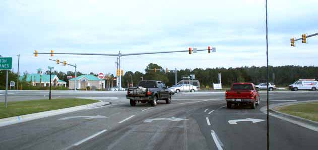 The photo shows signal pole locations at the main intersection from the minor street approach.