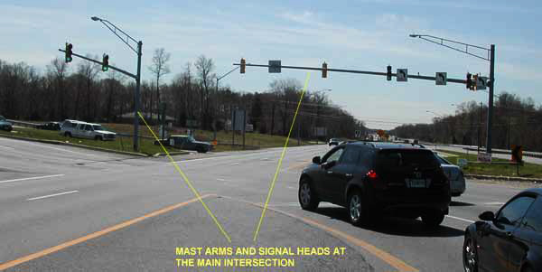 The photo has arrows pointing to mast arms and signal heads at the main intersection of MD 210 and MD 228 in Accokeek, MD.