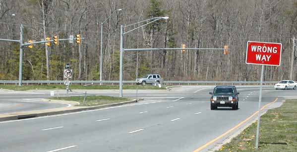 The photo shows signal pole locations at the main intersection viewed from the minor street approach.