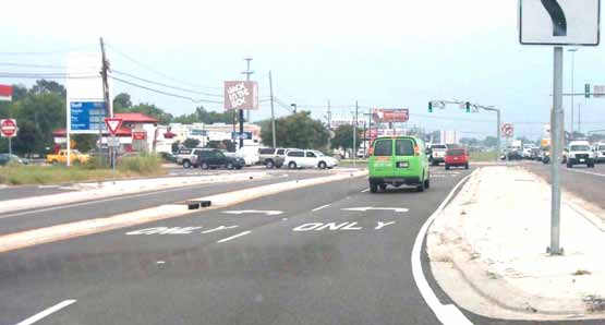 The photo shows pavement markings at a displaced left-turn (DLT) intersection in Baton Rouge, LA.