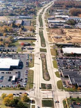 The photo shows a median U-turn (MUT) intersection treatment in a corridor in Michigan.