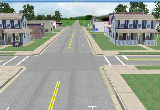 Town baseline condition. The figure depicts a simulator screenshot of the baseline town condition. It shows a daytime view of a two-lane undivided main roadway running straight down the center of a small town. The town consists of small homes and stores lining the main roadway. A standard intersection is clearly visible in the foreground, and a second intersection is barely visible in the background. All roadways in the town have curbs, gutters, and sidewalks. They also have double yellow centerlines which are interrupted at the intersections. The minor intersecting roadway running horizontally across the screen has marked crosswalks and stop bars on either side. Marked parking spaces are visible on either side of the main roadway, but no motor vehicles are parked in these spaces.