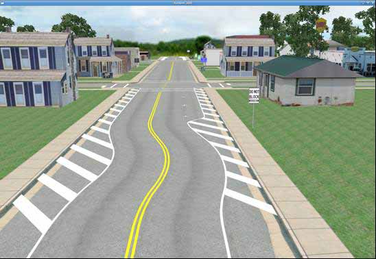 Painted chicanes condition. The figure depicts a simulator screen capture of the painted chicanes town condition. It shows a daytime view of a main two-lane undivided roadway running down the center of a small town. The town consists of small homes and stores lining the main roadway. A standard intersection is clearly visible in the foreground, and a second intersection is barely visible in the background. All roadways in the town have curbs, gutters, and sidewalks. They also have double yellow centerlines which are interrupted at the intersections. The minor intersecting roadway running horizontally across the screen has marked crosswalks and stop bars on either side. Marked parking spaces are visible on either side of the main roadway, but no motor vehicles are parked in these spaces. The main difference of this simulated condition from the baseline condition is that a painted chicane is clearly visible at the entrance to the town. This painted chicane has the same geometry as the analogous curb and gutter chicane, consisting of a compound curve which produces a series of temporary lateral lane shifts before entering the town, except it is implemented by painted marking patterns instead of by concrete. The marking patterns are created by areas of diagonal white hatch mark bands painted on the roadway. The second painted chicane at the exit from the town is barely visible.